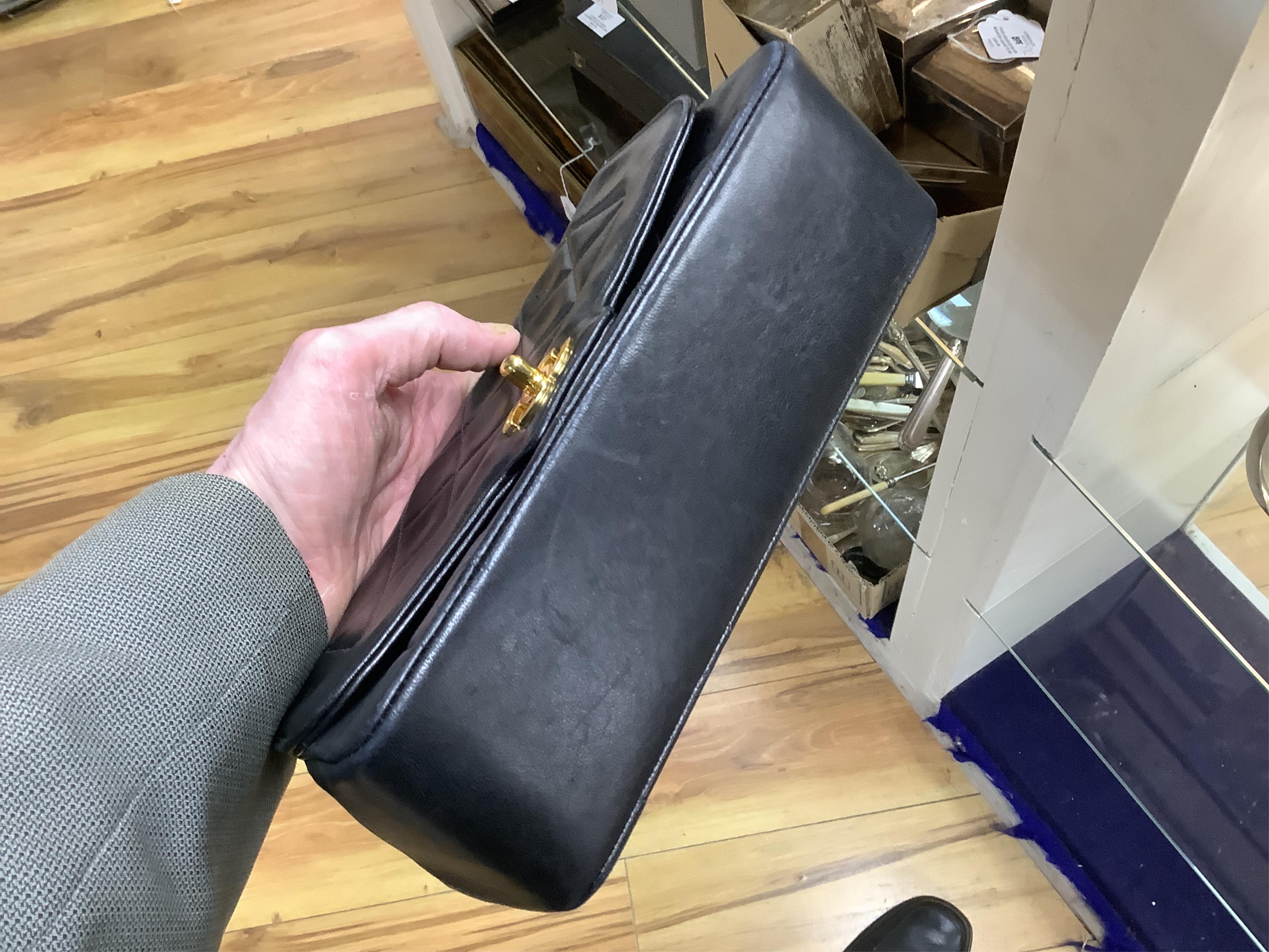 A late 1980’s Chanel black leather Diana shoulder bag with original dust cover and bag, Chanel authenticity card numbered 1944645, interior date code rubbed, 23cm wide, Provenance: Purchased by the vendor, 26 Old Bond St